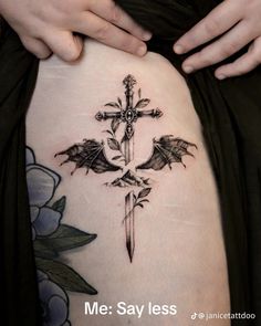 a cross tattoo on the side of a woman's thigh