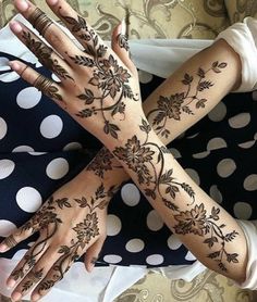 two hands with henna tattoos on them