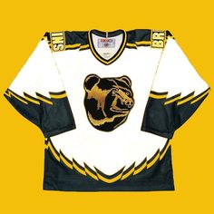 an old hockey jersey with a bear on the front and side, sitting against a yellow background