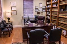 an office with chairs, desk and bookshelves