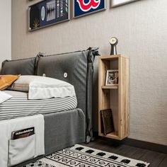 a bedroom with a bed, nightstand and pictures on the wall