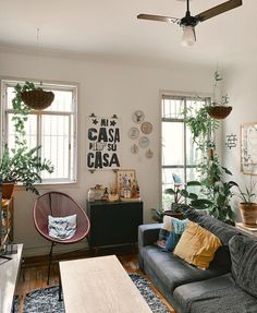 a living room filled with furniture and plants