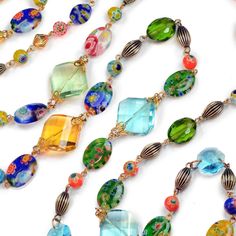 "For this necklace, colorful millefiori glass beads are blended with faceted crystal prisms in olivine green, sun yellow and aqua blue. Grooved metal beads are finished in warm bronze, providing a rich background for the color drenched beads. Millefiori means 'thousand flowers.' Bundles of tiny glass filament rods are sliced, then fired to meld their brilliant colors and floral patterns. No two beads are ever identical. Wear long or doubled. From our Candy Glass Collection. Style N586. Size: 48\ Multicolor Crystal Jewelry With Spacer Beads, Oval Glass Beaded Jewelry, Multicolor Glass Necklaces With Faceted Beads, Multicolor Crystal Beaded Chain Necklace, Green Glass Jewelry With Faceted Beads, Green Faceted Glass Beads, Green Crystal Beaded Necklace For Gift, Green Crystal Beaded Necklaces As Gift, Colorful Glass Beaded Jewelry