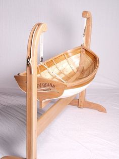 a small wooden boat is sitting on a stand