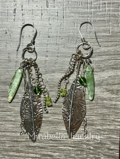 Long boho/hippie dangle earrings.  Sterling silver was formed into a leaf shape, hammered and given a light patina.  There are Peridot and Prehnite  beads that hang from silver chain.  Sterling silver ear wires.   Everything is handmade by me in my home studio in coastal North Carolina using conventional silversmith technique's. Bohemian Sterling Silver Hammered Earrings, Bohemian Hammered Sterling Silver Earrings, Bohemian Green Leaf-shaped Jewelry, Bohemian Silver Hammered Earrings, Silver Hammered Bohemian Earrings, Bohemian Leaf-shaped Metal Earrings, Bohemian Leaf-shaped Metal Jewelry, Bohemian Nickel-free Leaf-shaped Earrings, Silver Wire Wrapped Nature-inspired Earrings