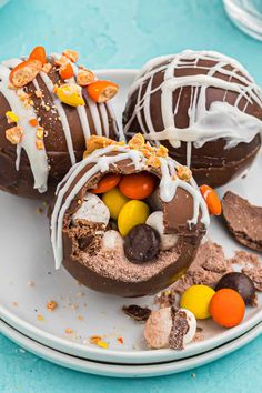 chocolate covered donuts on a plate with candy and candies all around them,