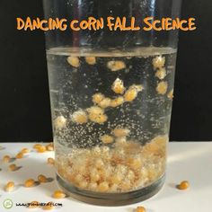 a glass filled with corn kernels on top of a table