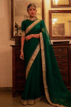 a woman in a green and gold sari