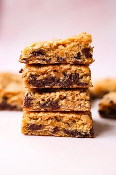 chocolate chip granola bars stacked on top of each other in front of some cookies