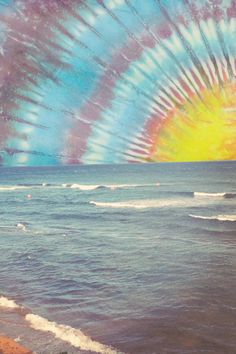 the sun is setting over the ocean with waves crashing in front of it and an artistic tie - dye effect