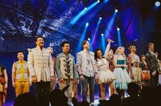 a group of people standing on top of a stage next to each other in front of a crowd