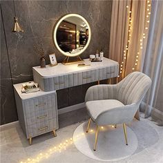 a dressing table with a mirror, chair and lights on the wall in a room