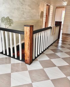 a black and white checkered floor in an empty room with a railing on it