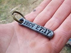 a hand holding a keychain with the word prom written on it