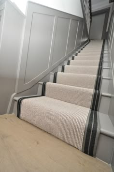 there is a set of stairs with carpet on the bottom and bottom, leading up to the second floor