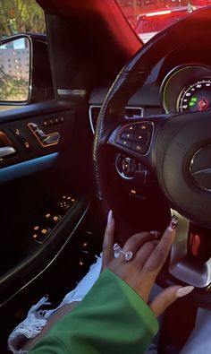 a woman driving a car with her hands on the steering wheel and dashboard lights showing