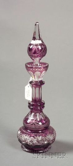 a purple glass candle holder with a tag on it