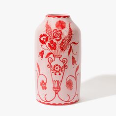 a red and white vase with flowers painted on it