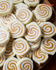 a plate full of white and orange swirled lollipops