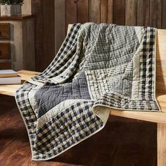 a wooden bench with a black and white checkered blanket on it