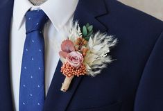 a man in a blue suit with a boutonniere