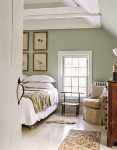 a bedroom with green walls and white furniture