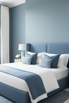 a bedroom with blue walls and white bedding, along with two lamps on either side of the bed