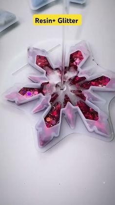 an image of a flower made out of ice cubes on a white table with the words resinin + glitter written below it