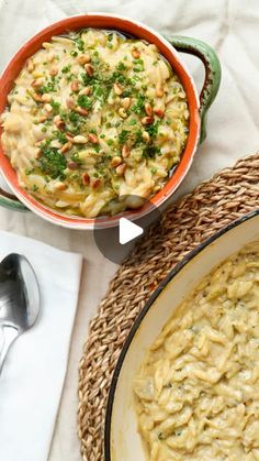 two bowls filled with macaroni and cheese on top of a white table cloth