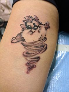 a woman's leg with a cartoon character tattoo on the side of her thigh