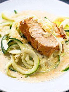 a white plate topped with meat and zucchini noodles