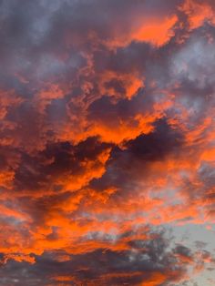 the sky is filled with orange and pink clouds