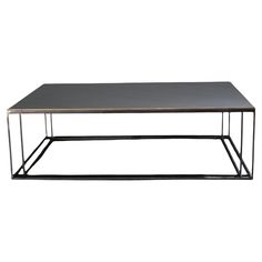 a black coffee table with metal legs and a gray top, on a white background