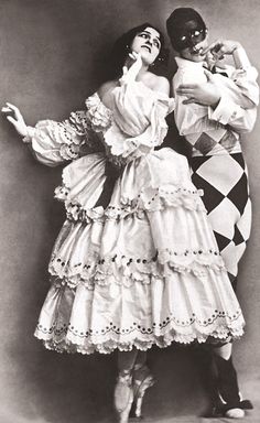 an old photo of two people dressed in costume and posing for the camera with their arms around each other