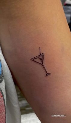 a woman's arm with a small tattoo of a martini glass on the side