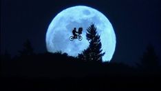 a bike rider is silhouetted against the full moon