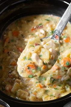 a ladle full of soup with meat and vegetables in it, ready to be eaten