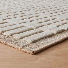 a white rug on top of a wooden floor with an area rug in the middle