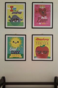 four framed posters on the wall above a crib in a child's room