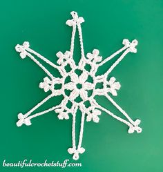 a crocheted snowflake on a green background