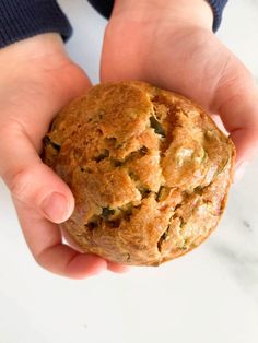 a person holding a muffin in their hands