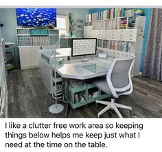 there is a computer desk with two monitors on it and a shelf full of files