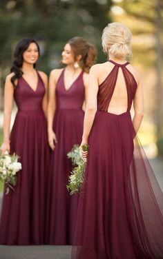 three bridesmaids in maroon dresses standing together