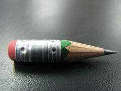 a pencil with a green and red stripe on it sitting on top of a table