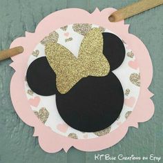 a paper plate with a minnie mouse head on it and gold glitter bow at the top