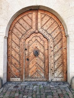 an old wooden door is open on a brick walkway