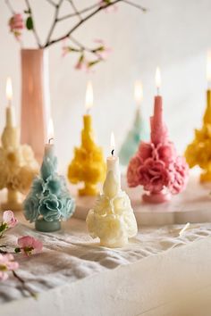 there are many different colored candles on the table