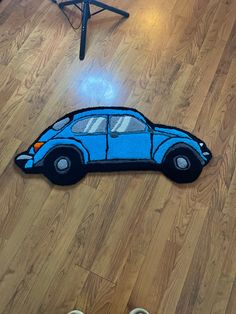 a blue car shaped rug sitting on top of a wooden floor