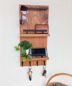 a wooden shelf with keys, cell phone and wallet hanging from it's sides