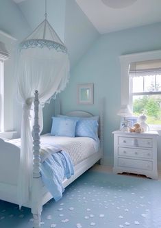 a white canopy bed sitting in a bedroom next to a dresser and window on top of a blue floor